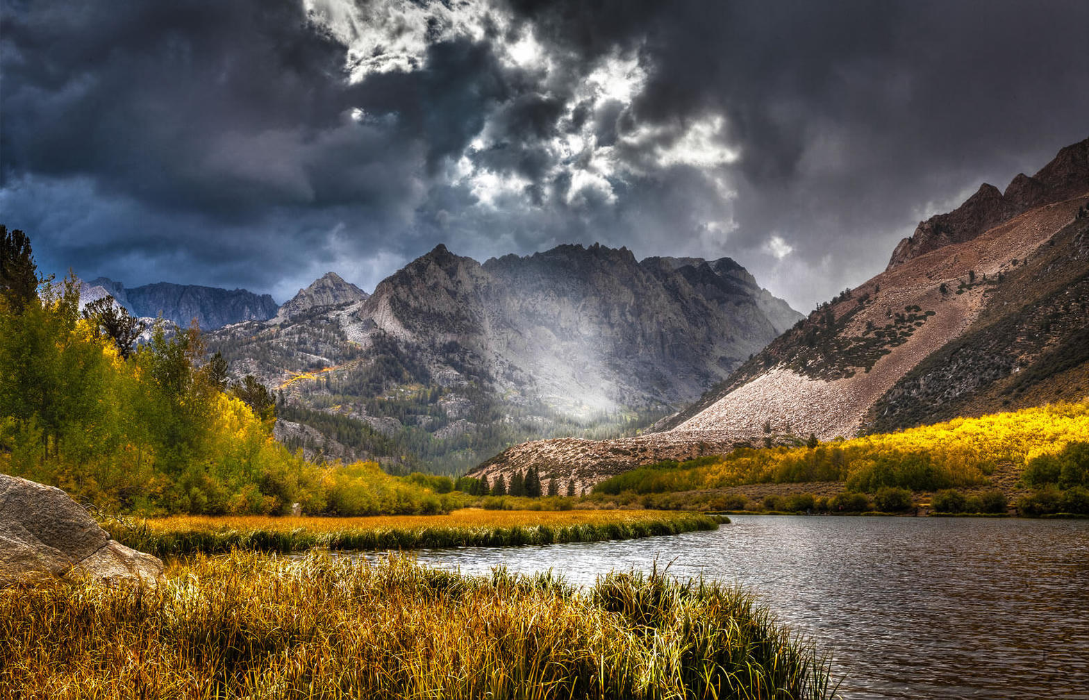 Dramatic Eastern Sierra mountains and autumn aspens by a lake